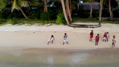 African-children-running-along-Madagascar-beach-chasing-drone