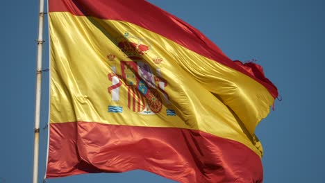 Slow-motion-Spanish-satin-flag-heraldry-rippled-fabric-blowing-in-breeze-closeup