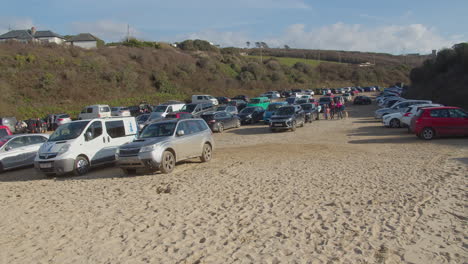 Family-arriving-on-full-parking-lot-at-Crantock-Beach,-Cornwalll,-wide-shot