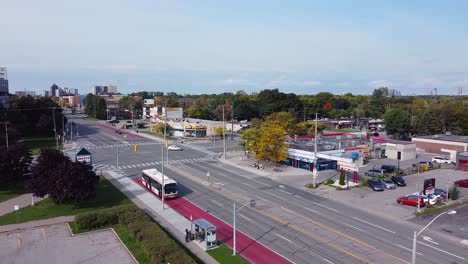 Toronto-Transit-Commission-bus-in-bus-lane-arriving-at-bus-stop-to-pick-up-passengers-waiting