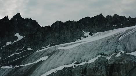 Alaskische-Zerklüftete-Bergkette,-Drohne,-Die-Bei-Sonnenaufgang-Durch-Die-Wolken-Und-Berge-Fliegt