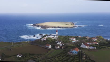 Drone-View-Push-In-En-Un-Faro-Y-Una-Isla-En-El-Océano-Atlántico,-Cielo-Nublado-En-Topo,-Isla-De-São-Jorge,-Las-Azores,-Portugal