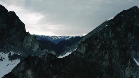 Cordillera-Escarpada-De-Alaska,-Drones-Volando-A-Través-De-Las-Nubes-Y-Sobre-Una-Cresta-En-Las-Montañas-Al-Amanecer