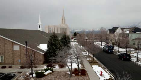 Ascending-above-a-tree-to-reveal-the-LDS-Oquirrh-Mountain-Temple-in-Winter