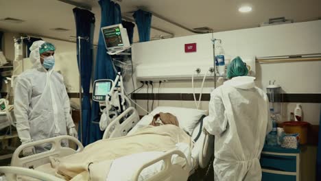 Médicos-Que-Atienden-Al-Paciente-Covid-19-Acostado-En-Una-Cama-De-Hospital
