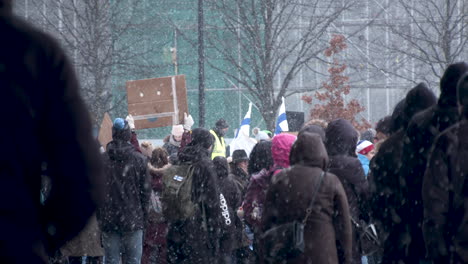 Wide-shot-of-the-crowd-of-people-gathered-for-the-covid-19-demonstrations,-carrying-flags-and-placards,-cold-winter-day