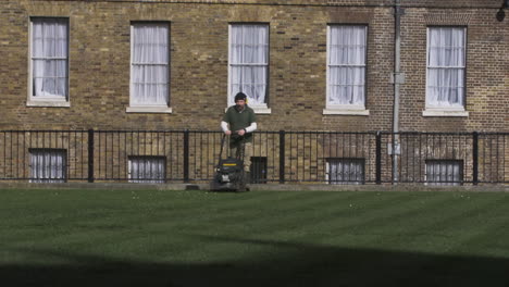 Gardener-Using-Petrol-Lawnmower-On-Abingdon-Street-Gardens-In-London