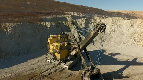 Rotating-drone-shot-of-large-crane-at-a-rock-quarry