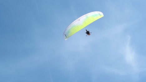 Paraglider-passing-overhead-in-the-blue-sky