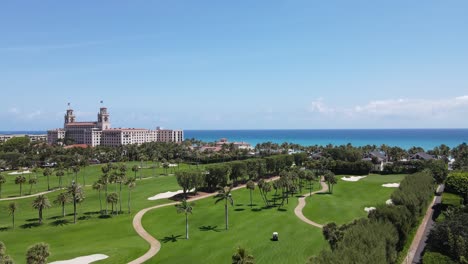 Palm-Beach,-Florida,-panoramic-aerial-view-of-the-ocean-and-beautiful-well-maintained-golf-course-and-turquoise-blue-ocean