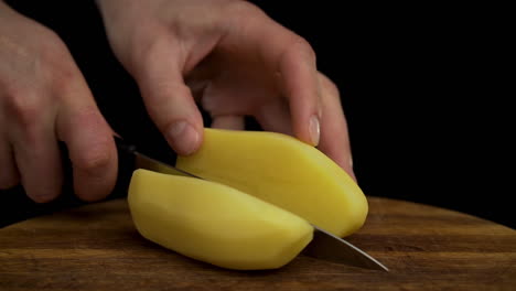 Caucasian-man's-hands-chop-potato-in-kitchen,-close-up-slow-motion