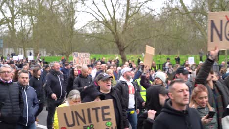 Large-crowds-marching-holding-signs-at-the-anti-lockdown-protest-in-London,-UK