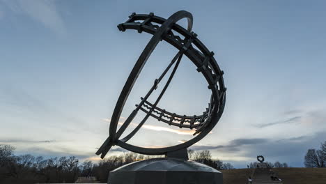Bronze-Sundial-With-The-Wheel-of-Life-Sculpture-In-Background-At-Sunset-In-Vigeland-Park,-Frogner-Park,-Oslo,-Norway