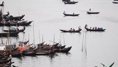Traditional-passenger-boats-moving-and-some-are-anchored-at-sadarghat-port-in-Buriganga-River,-Dhaka,-Bangladesh