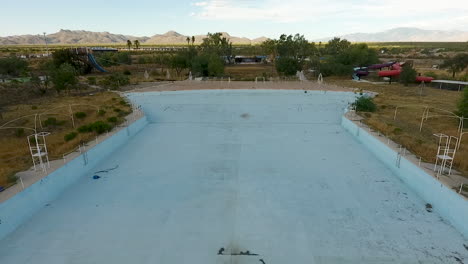 Drone-shot-of-abandoned-waterpark-starting-over-wave-pool,-at-Breakers-in-Tucson-Arizona