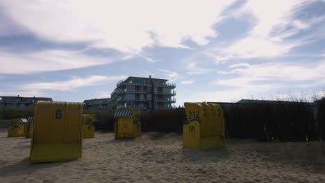beach-chairs-on-a-beach-with-a-hotel-in-the-background