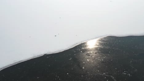 Vista-Superior-Del-Paisaje-Nevado-De-Invierno-En-La-Isla-De-Los-Pájaros,-Polonia-Durante-El-Amanecer-Con-Reflejo-En-El-Agua---Toma-Aérea-De-Drones