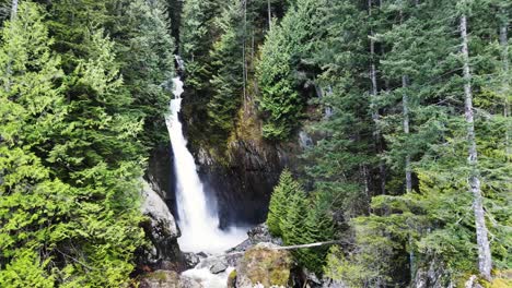 Aerial-shot-of-Silver-Falls-waterfall-pulling-back-through-trees
