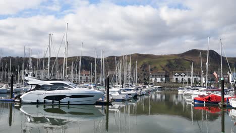 Yachts-speedboats-and-sailboats-moored-under-luxury-Conwy-mountainous-marina-waterfront-North-Wales