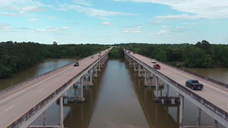 Aerial-of-cars-driving-on-bridge-that-crosses-over-the-San-Jacinto-River-in-Houston,-Texas