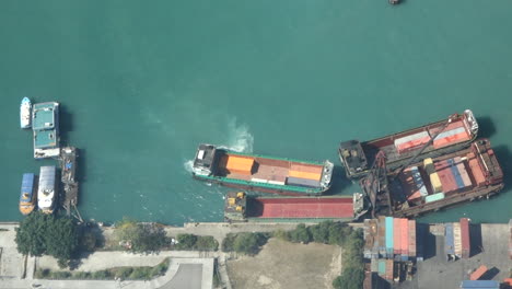 Top-down-view-of-a-container-ship-docking-against-another-boat