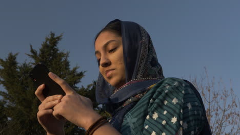 Junge-Muslimische-Teenagerin-Mit-Handy-Während-Des-Sonnenuntergangs