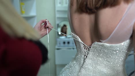 friend-Helps-the-bride-to-put-on-a-wedding-dress