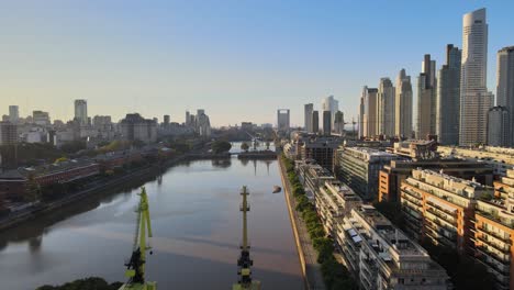 Aerial-shot-flying-over-cranes-in-Puerto-Madero-waterfront-at-sunset-in-Buenos-Aires-city