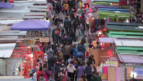 Fa-Yuen-street-market-stalls-as-large-crowds-of-shoppers-look-for-bargain-priced-vegetables,-fruits,-gifts,-and-fashion-goods-in-Hong-Kong