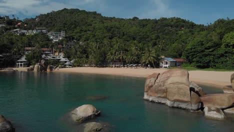 Beach-Resort-with-Turquoise-Water-and-Beautiful-Stones-Palm-Trees-and-Mountains-on-Koh-Tao-Thailand