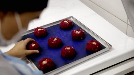 Red-velvet-cookie-dough-being-placed-on-a-pan-for-baking