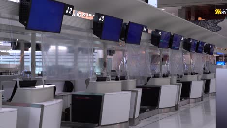 Leere-Check-in-Schalter-Mit-Blauen-Bildschirmen-Am-Flughafen-Wegen-Koronapandemie