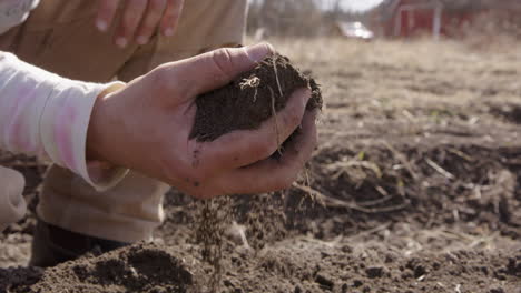 Hand-checks-the-soil-on-a-farm,-agriculture,-close-up-slow-motion