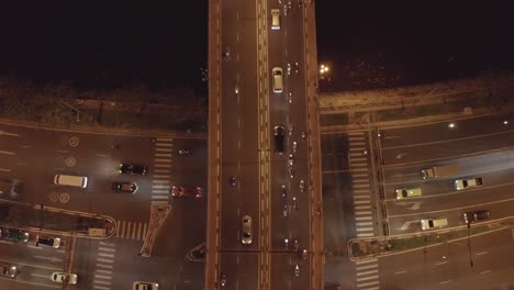 top-down-view-of-busy-traffic-bridge-and-underpass-at-night-with-streaks-from-moving-cars-and-motorbikes