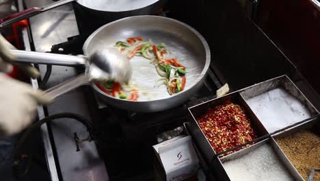 Chef-Profesional-Prepara-Pasta-Con-Salsa-Blanca-En-Una-Tienda-De-Comida-Callejera-En-Chat-Gali-En-Agra,-India,-El-7-De-Marzo-De-2021