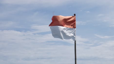 Indonesische-Flagge-Auf-Dem-Fahnenmast-Vor-Dem-Blauen-Himmelshintergrund