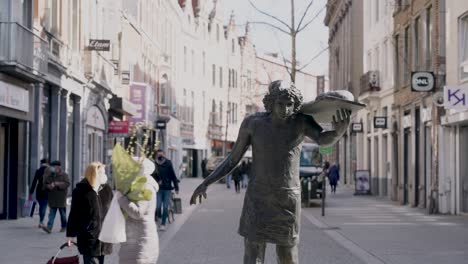 Iconic-statue-of-'The-Baker'-against-crowded-commercial-district-in-Leuven,-Belgium