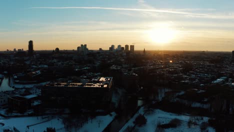 Aerial-view-of-Utrecht-during-the-sunset-and-a-frozen-lake-with-people-ice-skating