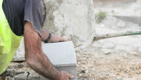 Construction-Worker-Holds-A-Concrete-Brick-At-Roadwork
