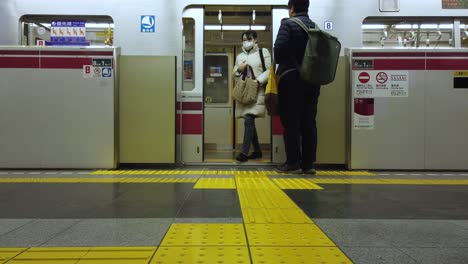 Tokio,-Japón:-Viajero-De-Tren-Subterráneo-Mientras-Llega-Acercándose-A-La-Plataforma-De-La-Estación-De-Metro-De-Tokio-En-Video-De-Cámara-Lenta-4k