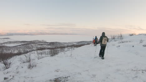 Excursionista-Con-Raquetas-De-Nieve-Y-Bastones-Caminando-En-Una-Montaña-Durante-El-Amanecer-En-La-Naturaleza-En-El-Norte-De-Suecia