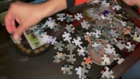 Hands-Assembling-Jigsaw-Puzzle,Help-Support-In-Teamwork,-Close-up-top-down