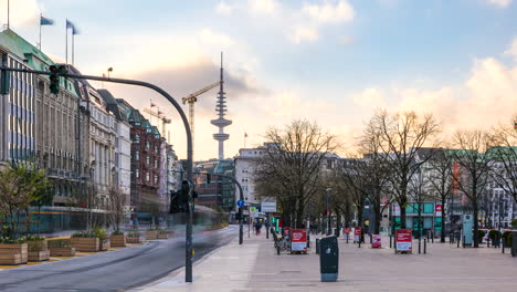 Time-lapse-shot-of-Jungfernstieg-urban-promenade-with-traffic-and-pedestrians-during-sunset-and-tv-tower-in-background