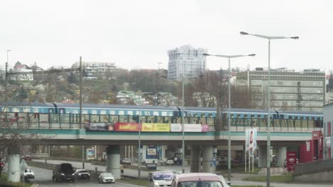Metro-in-Prague-going-over-viaduct-during-traffic-hour---Wide-static-shot