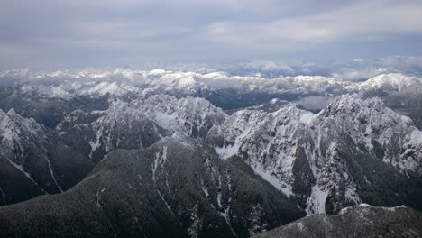 Volando-Sobre-Montañas-Cubiertas-De-Nieve-En-Un-Día-Nublado