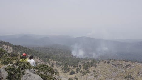 A-closeup-shot-of-Hispanic-hikers-sitting-on-top-of-the-Tlaloc-Mount-on-a-gloomy-day-in-Mexico-fire-in-the-forest
