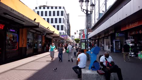SAN-JOSE,-COSTA-RICA---MAY-12,-2021:-time-lapse-shot-of-the-Avenida-Central-,-with-a-flow-of-people-coming-and-going