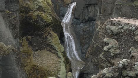 Stream-of-water-falling-through-rocks-at-Fjadrargljufur-Canyon,-Iceland