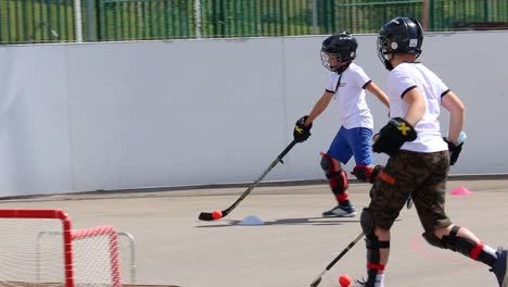 Boys-Playing-Hockey-Ball-Ball,-Running-With-Hockey-Stick,-Slow-Motion