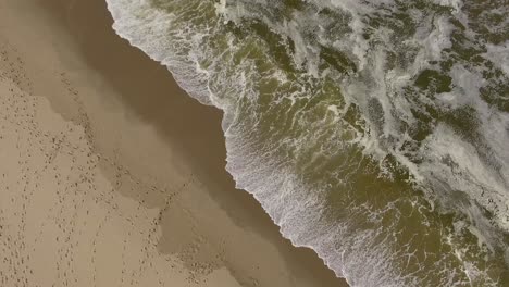 Aerial-top-down-view-of-low-tides-meeting-the-isolated-sandy-beach
